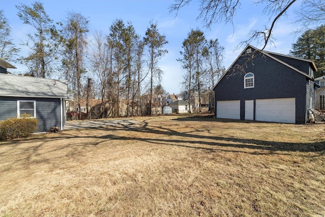 view of yard featuring a garage and driveway