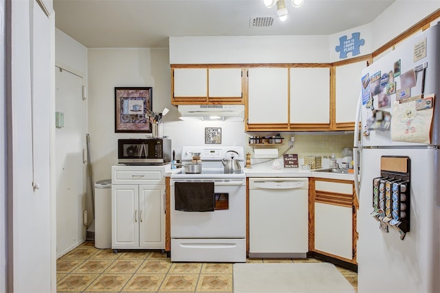 kitchen featuring visible vents, under cabinet range hood, white cabinetry, white appliances, and light countertops