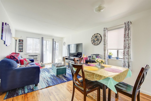 dining area with plenty of natural light, cooling unit, and wood finished floors