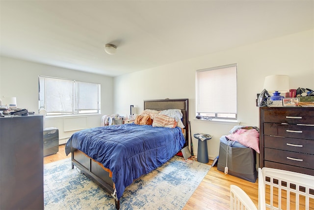 bedroom with a baseboard radiator and wood finished floors