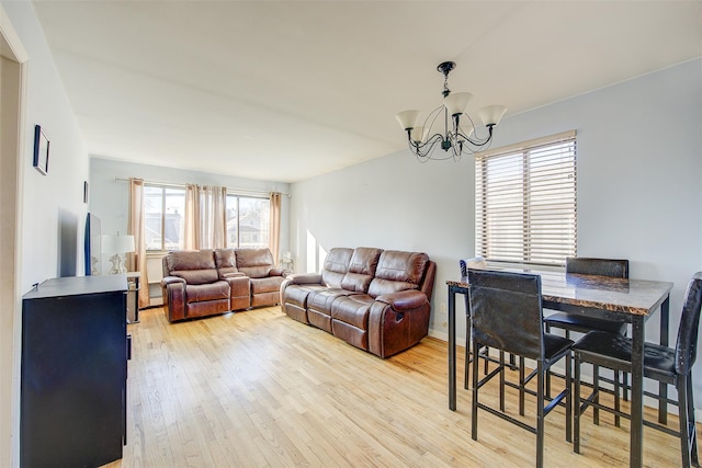 living room featuring light wood-type flooring and an inviting chandelier