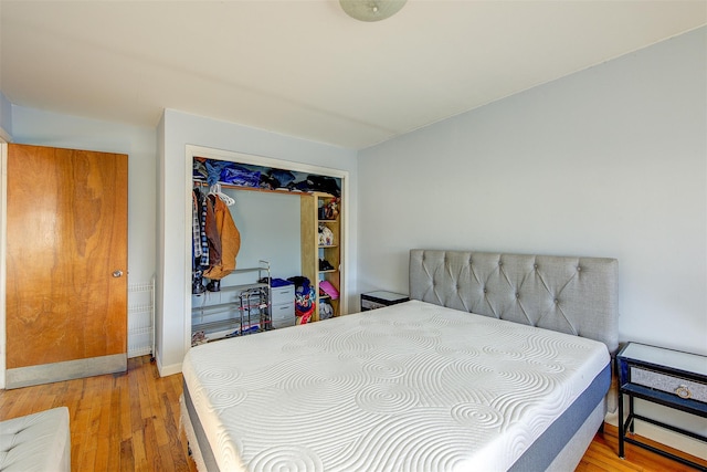 bedroom featuring wood finished floors, a closet, and baseboards