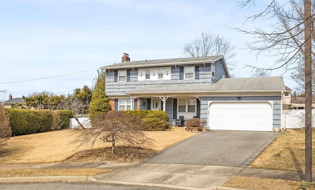 traditional home with aphalt driveway, an attached garage, a chimney, and fence