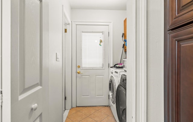 laundry room with laundry area, light tile patterned floors, and washer and clothes dryer