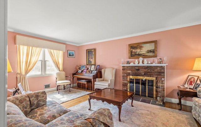 living room with a fireplace, crown molding, wood finished floors, and visible vents