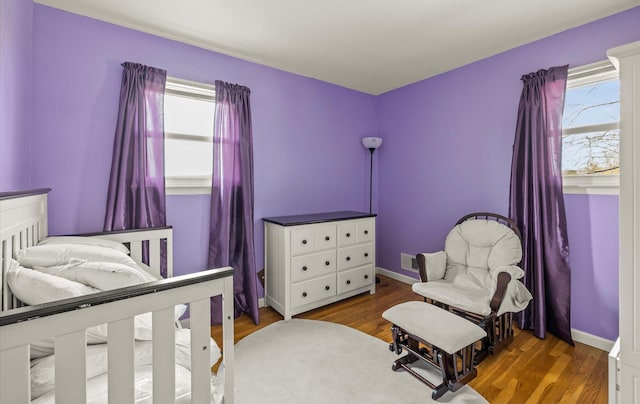 bedroom featuring visible vents, baseboards, and wood finished floors