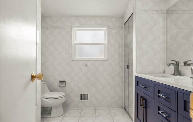 full bathroom with vanity, visible vents, tile walls, toilet, and tile patterned floors