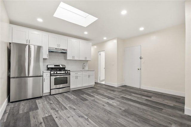 kitchen featuring wood finished floors, light countertops, under cabinet range hood, appliances with stainless steel finishes, and tasteful backsplash