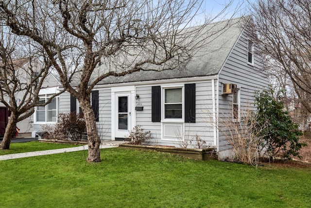 view of front facade featuring a front yard and a shingled roof