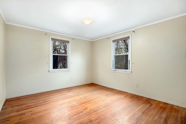 unfurnished room with baseboards, crown molding, and light wood-style floors