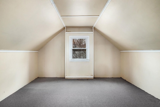 additional living space featuring lofted ceiling and carpet flooring