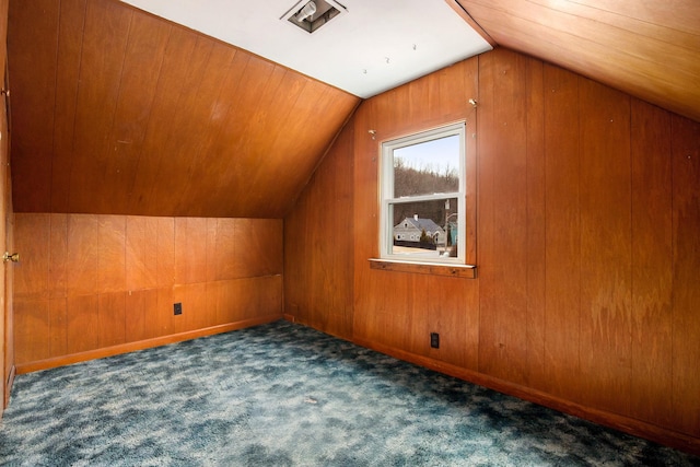 bonus room with carpet floors, wood walls, baseboards, and vaulted ceiling