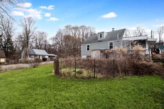 back of property featuring a chimney and a yard