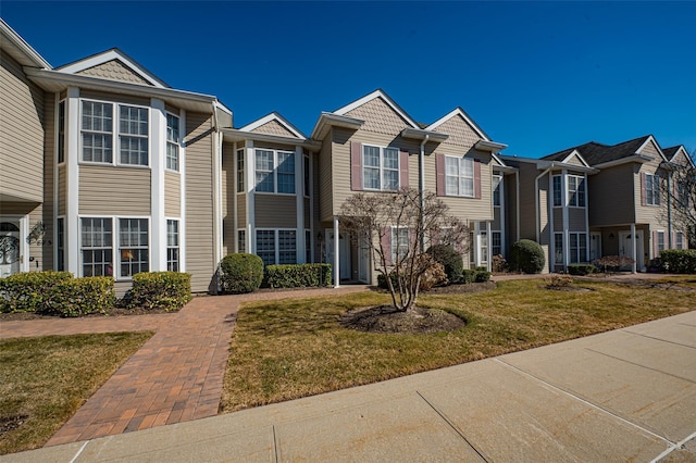 view of property with a residential view and a front lawn