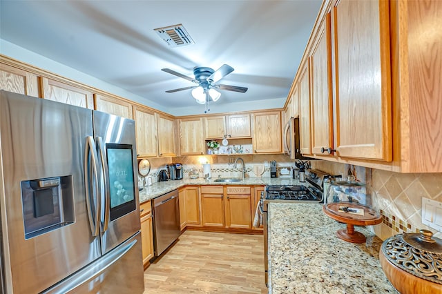 kitchen with tasteful backsplash, light stone countertops, visible vents, and appliances with stainless steel finishes