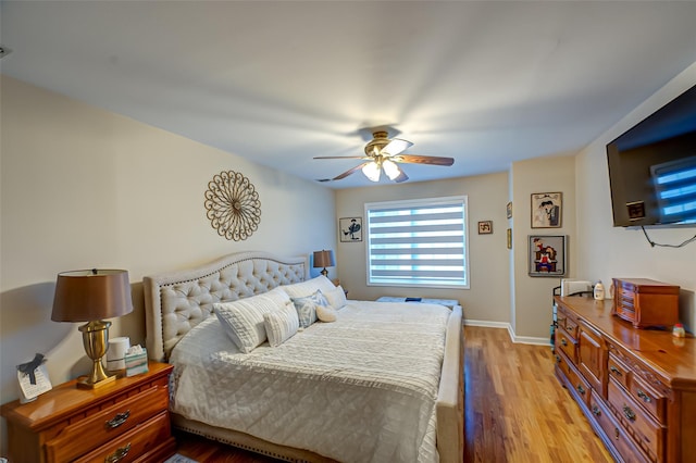 bedroom with baseboards, light wood-style floors, and a ceiling fan