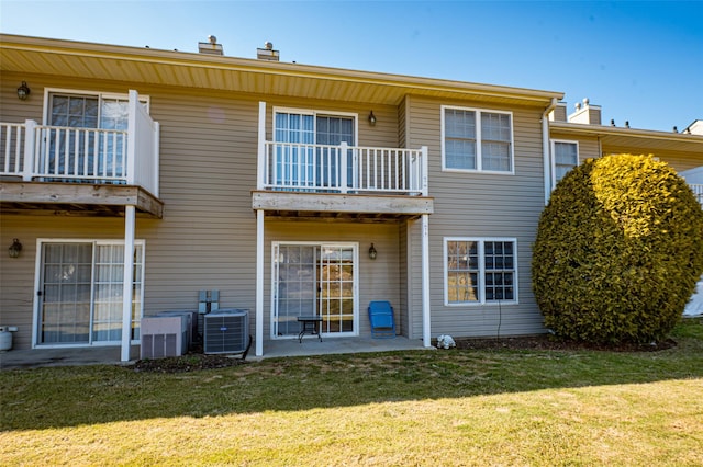 rear view of house featuring a yard, a patio, a chimney, and central AC