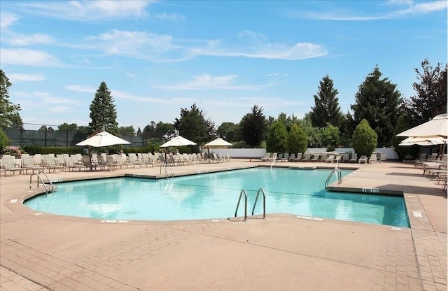 pool with a patio and fence