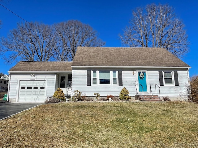 ranch-style house with a front yard, a garage, driveway, and roof with shingles