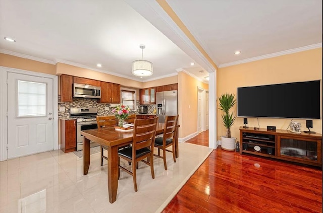 dining area featuring light wood finished floors, recessed lighting, and crown molding