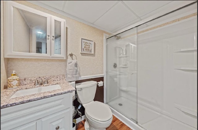 full bathroom with toilet, a stall shower, vanity, and wallpapered walls