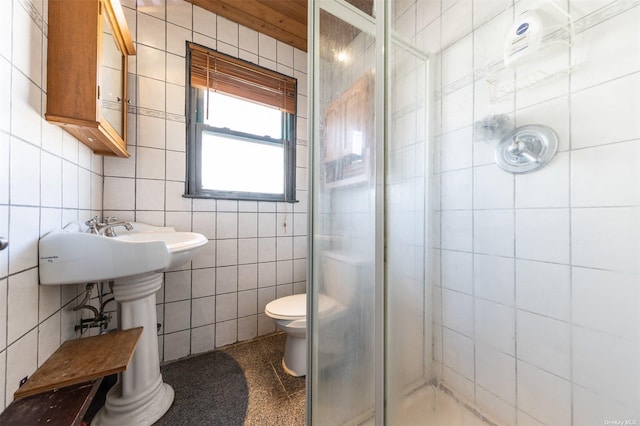 bathroom featuring tile walls, toilet, and a stall shower