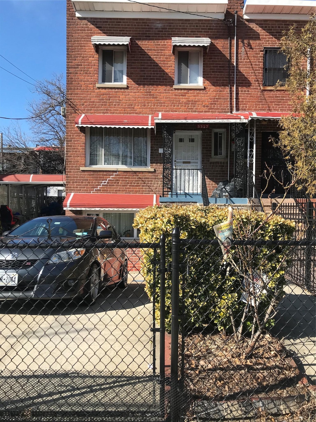 view of property featuring a fenced front yard, brick siding, and a gate