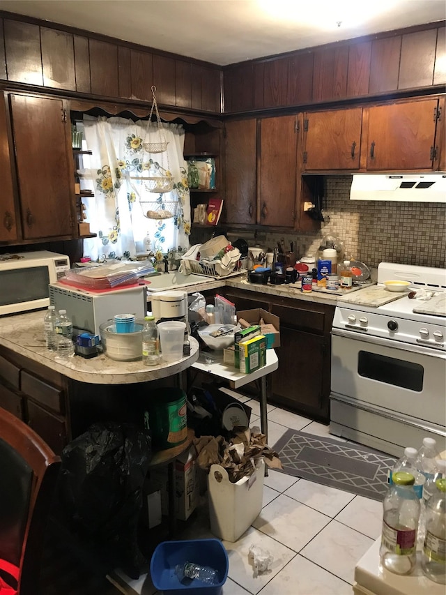 3327 Eastchester Rd, Bronx, NY 10469 - kitchen featuring light countertops, decorative backsplash, under cabinet range hood, and white appliances