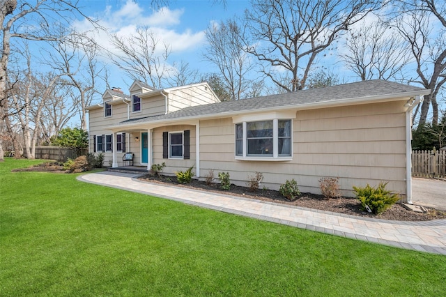 view of front of home with a front yard and fence