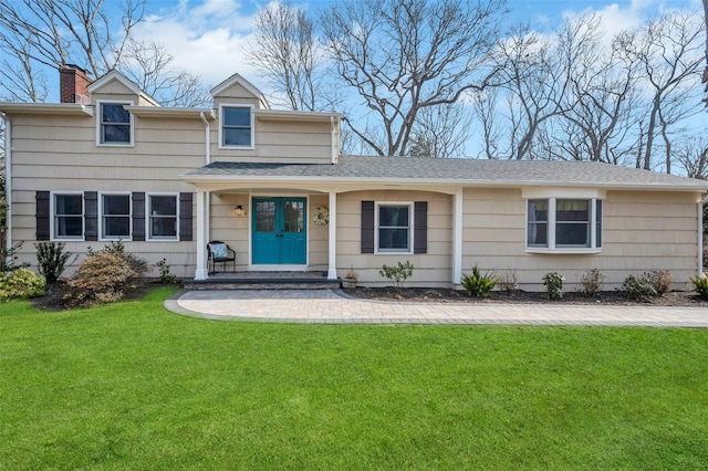 view of front of property featuring french doors, a chimney, a front lawn, and roof with shingles