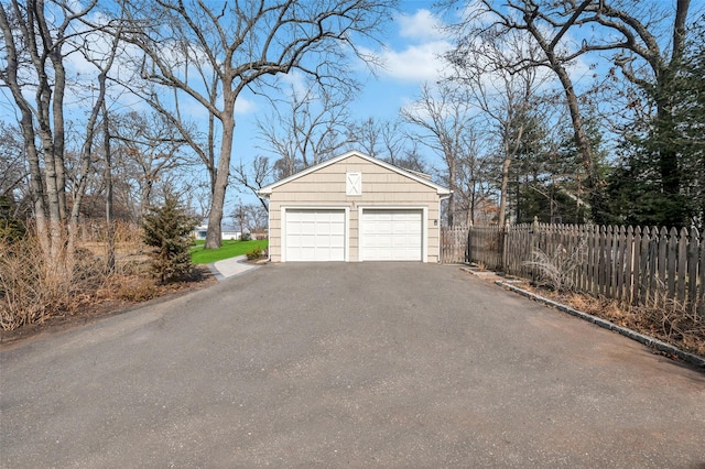 detached garage featuring fence