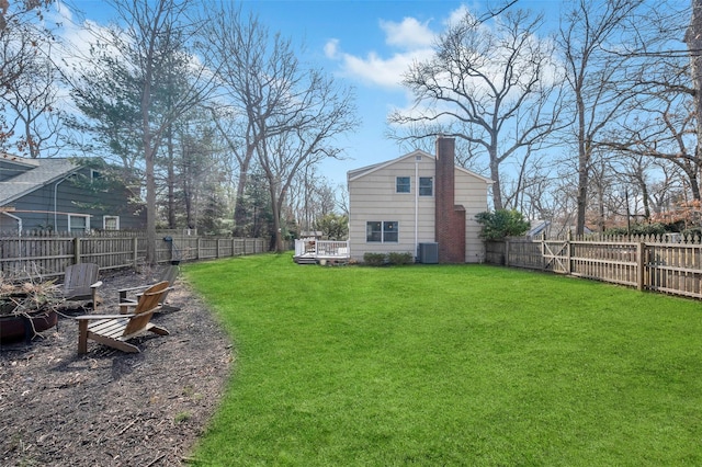 view of yard featuring central air condition unit, a fenced backyard, and a deck