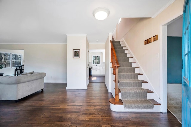 foyer entrance with stairway, wood finished floors, and ornamental molding