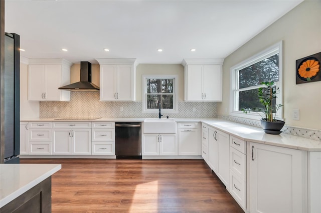 kitchen featuring light wood-type flooring, stainless steel appliances, white cabinetry, wall chimney exhaust hood, and a sink