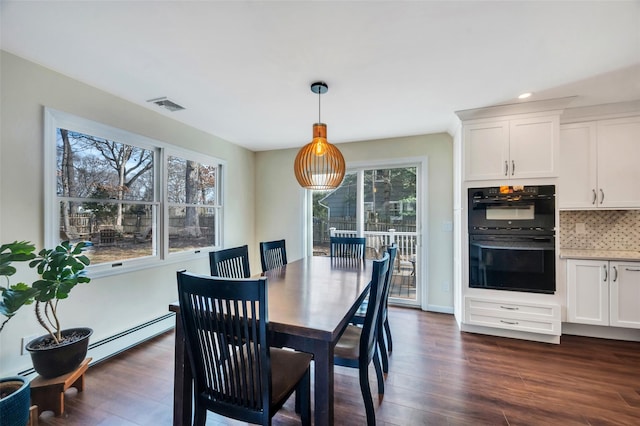 dining room with baseboard heating, dark wood-type flooring, and visible vents