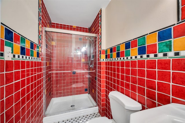 full bathroom with tile walls, toilet, and a shower stall