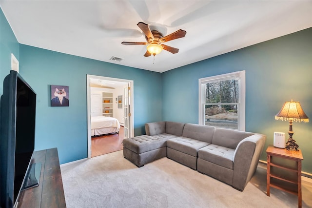 carpeted living area featuring visible vents, baseboards, and a ceiling fan