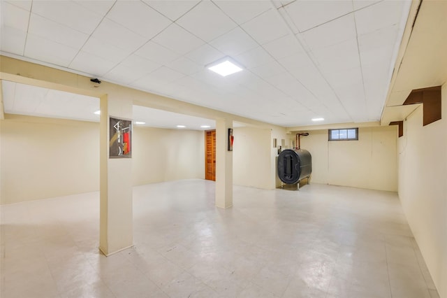 basement featuring light floors and heating fuel