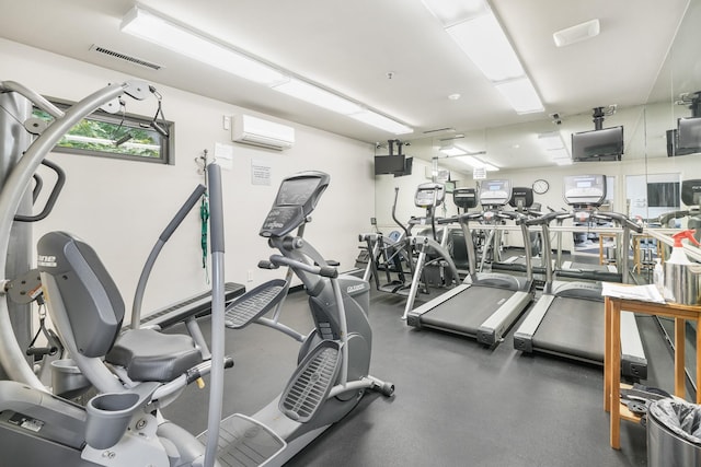 exercise room featuring visible vents and a wall mounted air conditioner