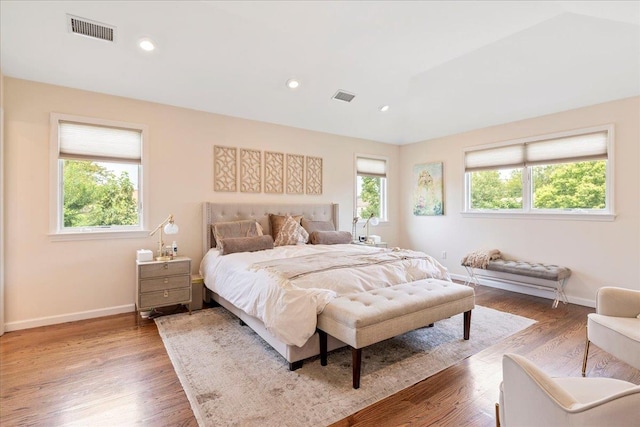 bedroom with wood finished floors, visible vents, and baseboards