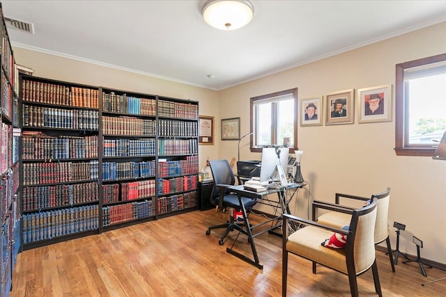 office area with visible vents, baseboards, wood finished floors, and crown molding