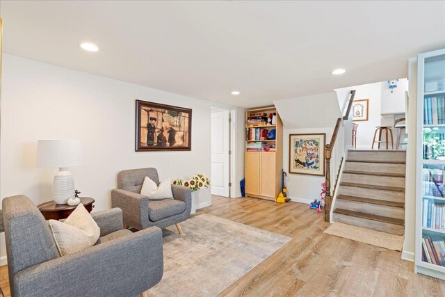 living area featuring recessed lighting, stairway, baseboards, and light wood finished floors