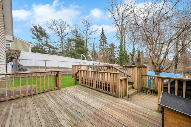 wooden deck featuring a lawn and fence