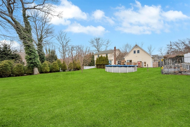 view of yard featuring a covered pool and fence