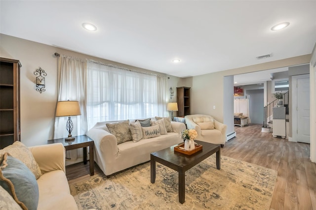 living room with light wood finished floors, visible vents, recessed lighting, and a baseboard radiator