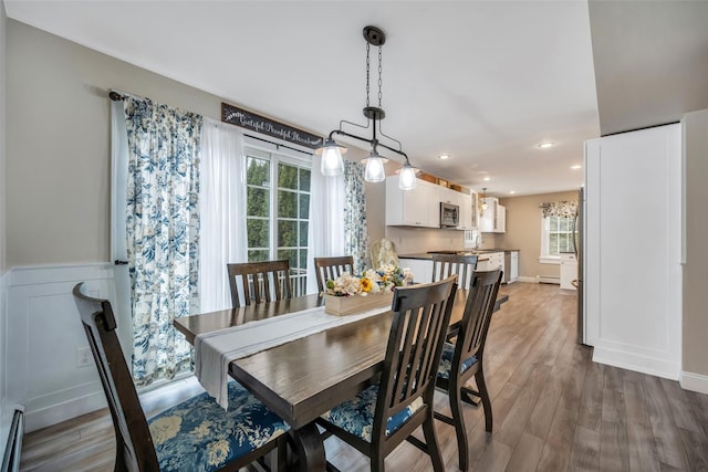 dining area featuring recessed lighting, a baseboard radiator, and wood finished floors