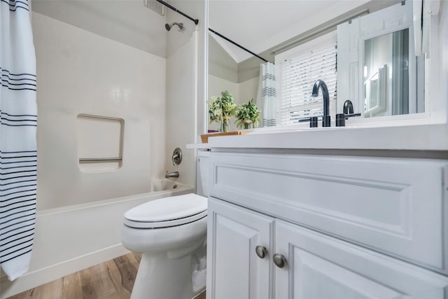 bathroom featuring vanity, wood finished floors, shower / tub combo, and toilet