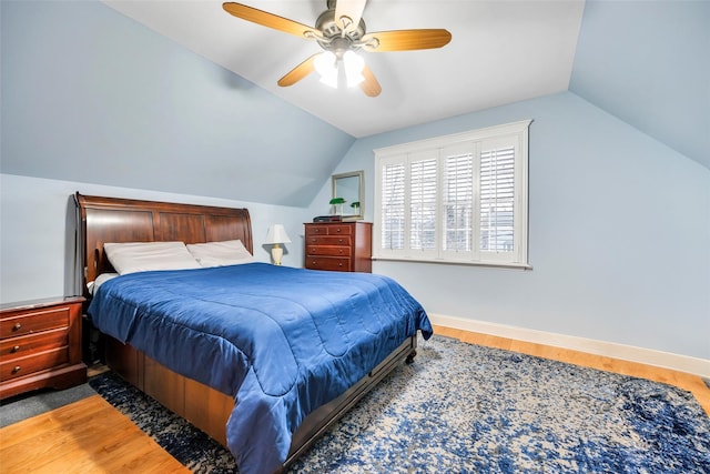 bedroom featuring ceiling fan, baseboards, lofted ceiling, and wood finished floors