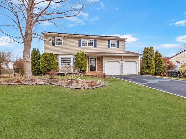 view of front of home featuring a garage, a front yard, solar panels, and driveway