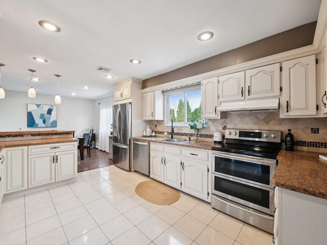 kitchen featuring a sink, light tile patterned floors, under cabinet range hood, and stainless steel appliances